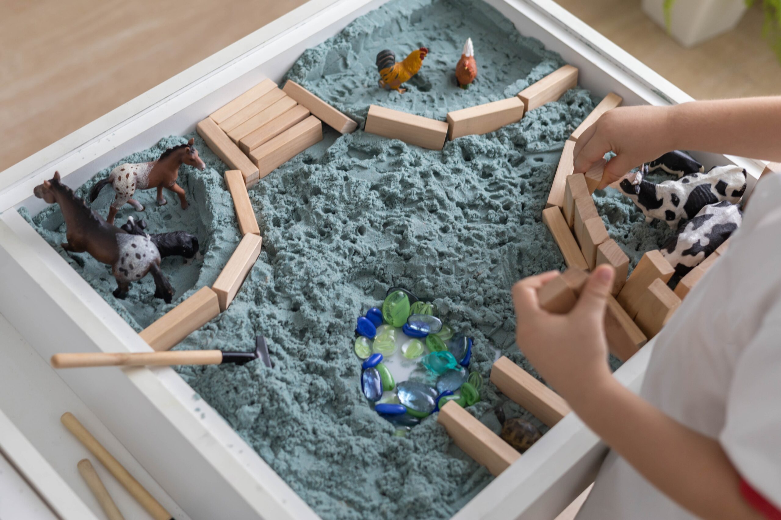 Niño jugando con una mesa sensorial.